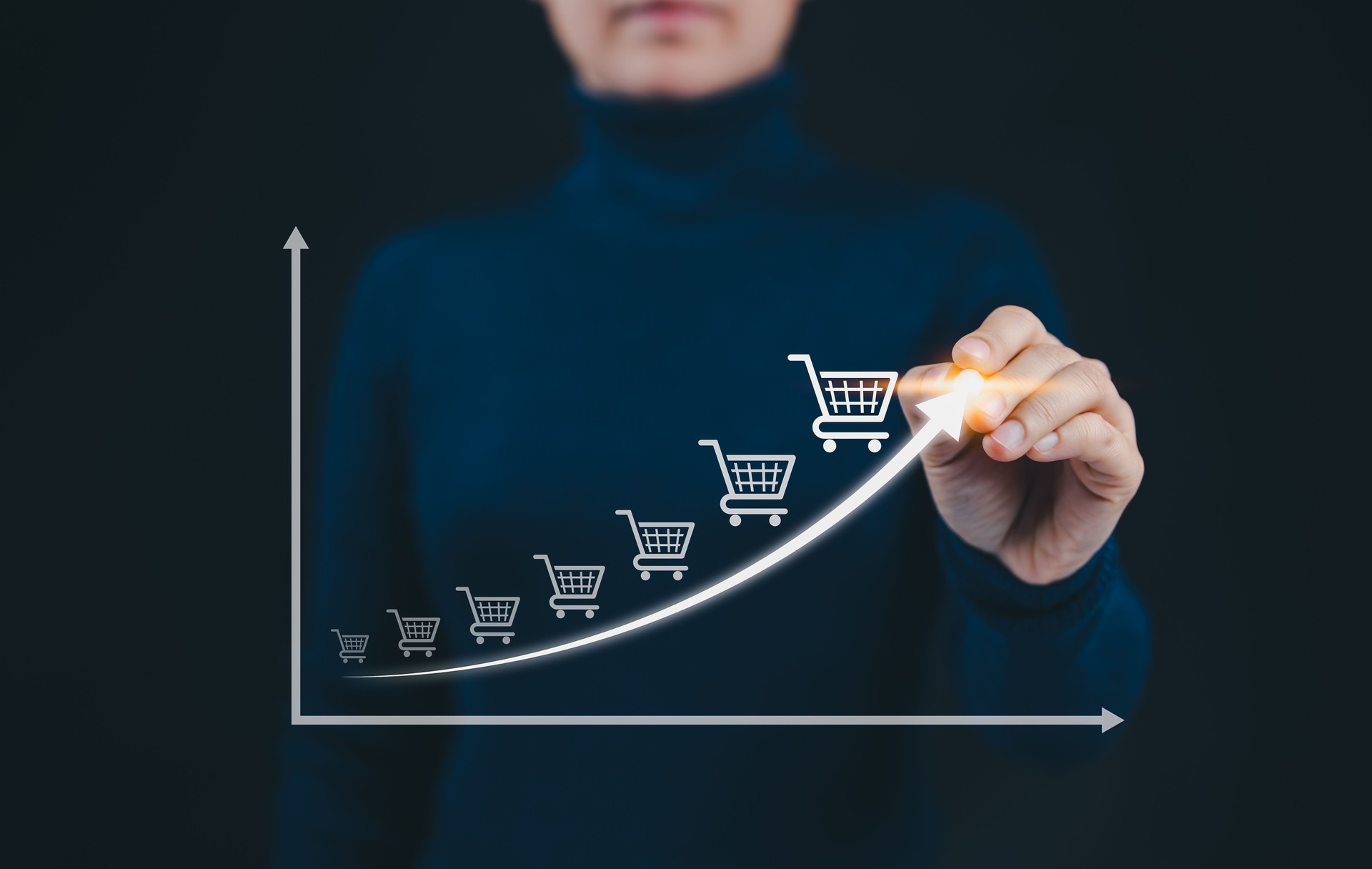E-commerce Growth and Online Sales Increase Concept. A person draws an upward arrow graph with shopping cart icons, symbolizing steady rise of ecommerce sales and online retail growth. sell target,